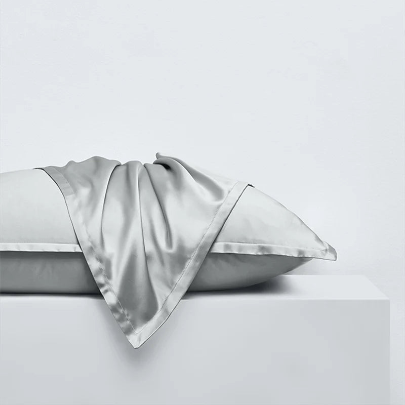 Détail de la texture d’une taie d’oreiller en soie de mûrier 30 mommes gris argenté, soie lisse, dense et brillante