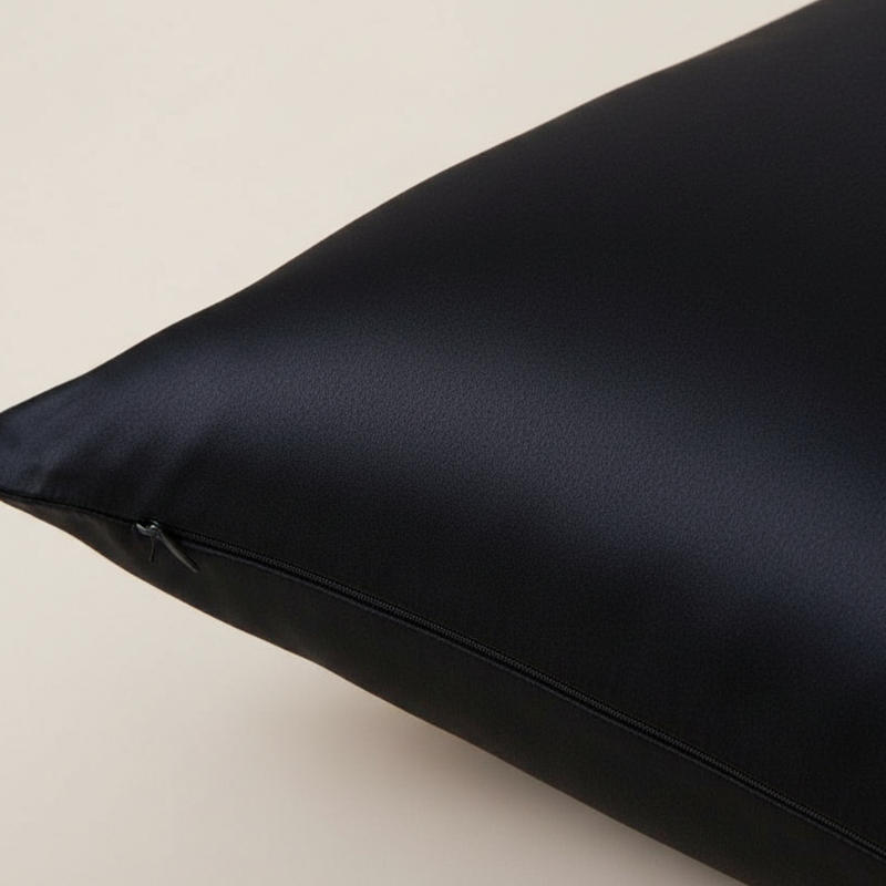 Détail de la texture d’une taie d’oreiller en soie de mûrier 25 mommes noire avec finition lisse et brillante