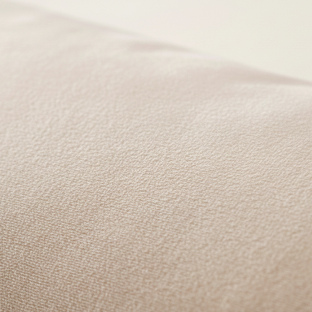 Détail de la texture d’une taie d’oreiller en velours gris clair, tissu doux, dense et délicatement lumineux