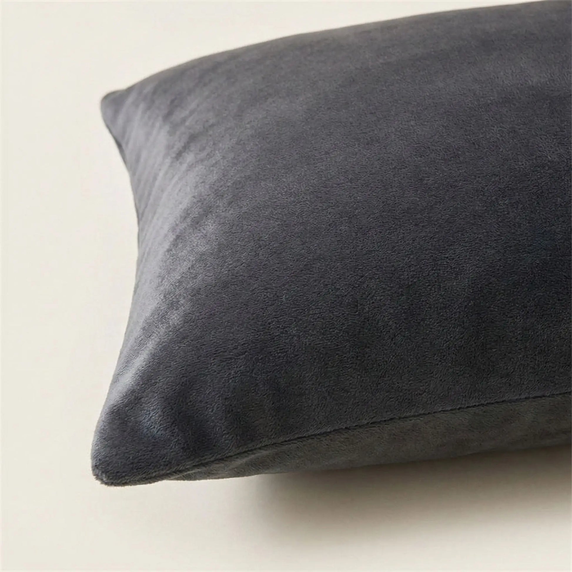 Détail de la texture d’une taie d’oreiller en velours noir, tissu dense, doux et légèrement lumineux