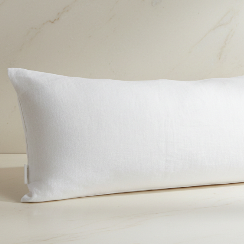 Détail de la texture d’une taie de traversin en lin blanc pois avec aspect naturel et légèrement texturé