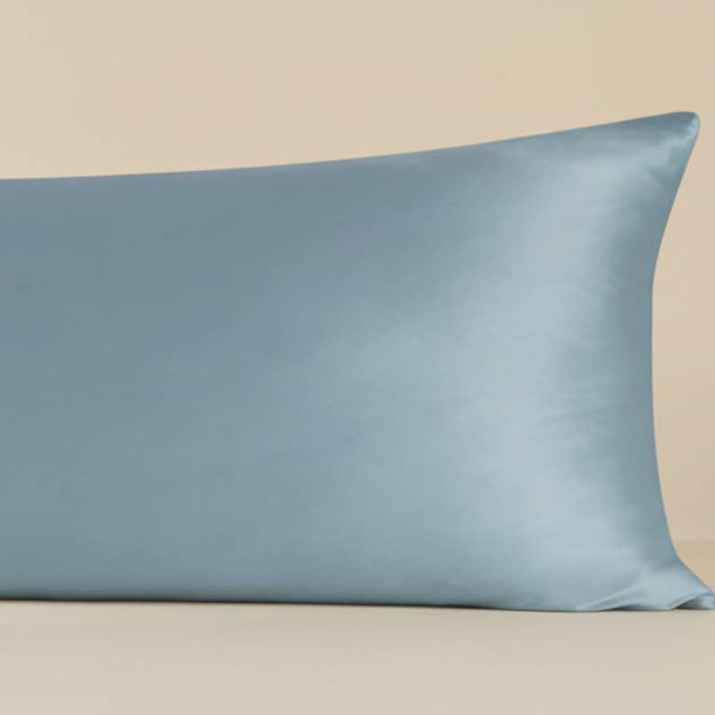 Détail de la texture d’une taie de traversin en soie de mûrier bleu grisé avec finition lisse et brillante