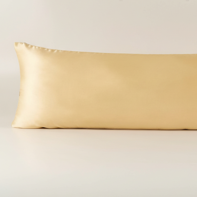 Détail de la texture d’une taie de traversin en soie de mûrier champagne avec finition lisse et brillante