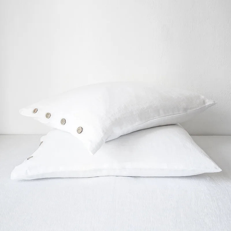 Deux taies d’oreiller en lin blanc neige présentée seule sur fond clair