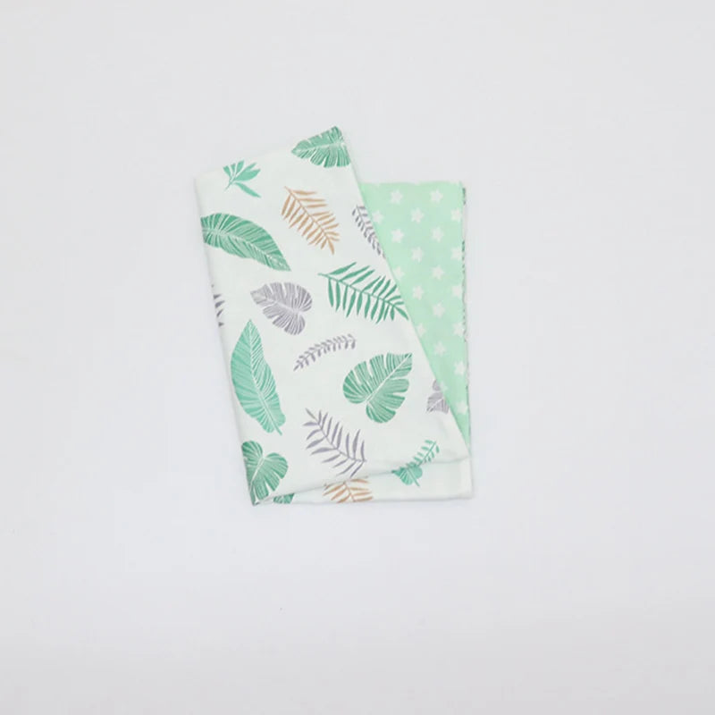 Taie d’oreiller bébé en coton à motif feuilles vertes pliés seule sur fond clair