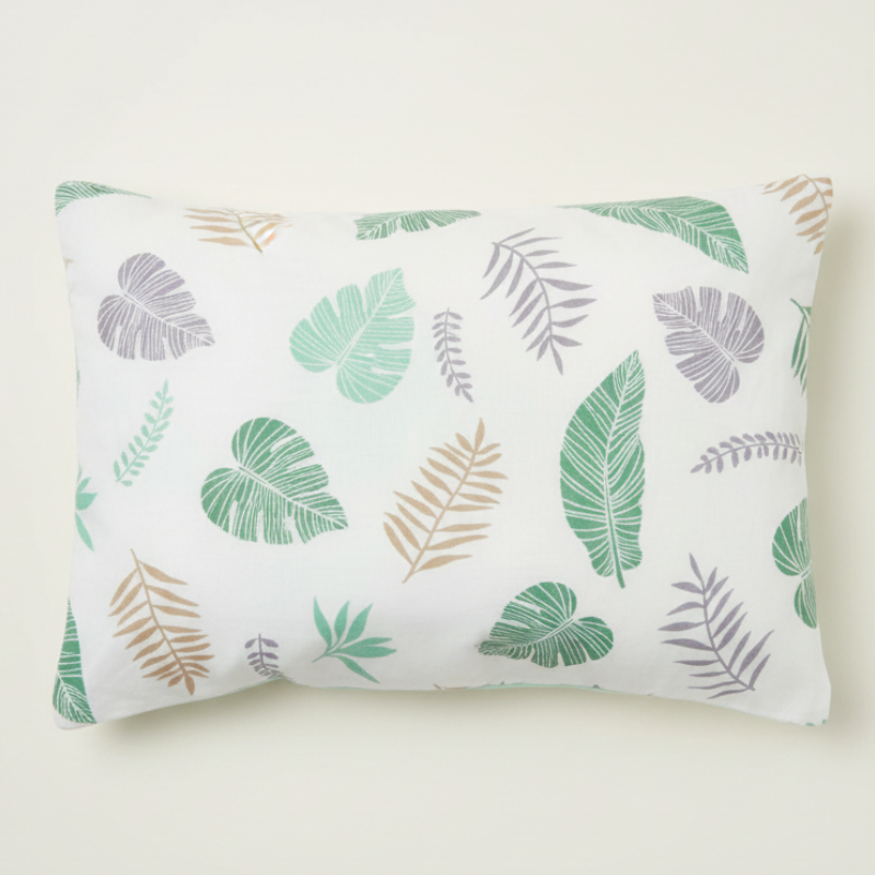Taie d’oreiller bébé en coton à motif feuilles vertes présentée seule sur fond clair