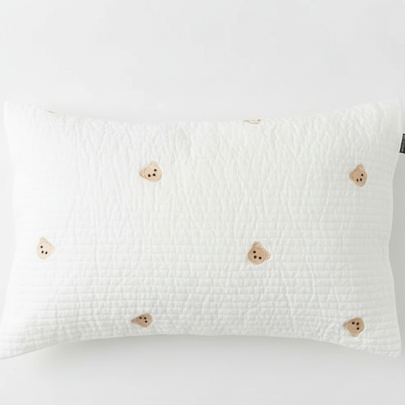 Taie d’oreiller bébé en coton matelassé à motif oursons bruns présentée seule sur fond clair