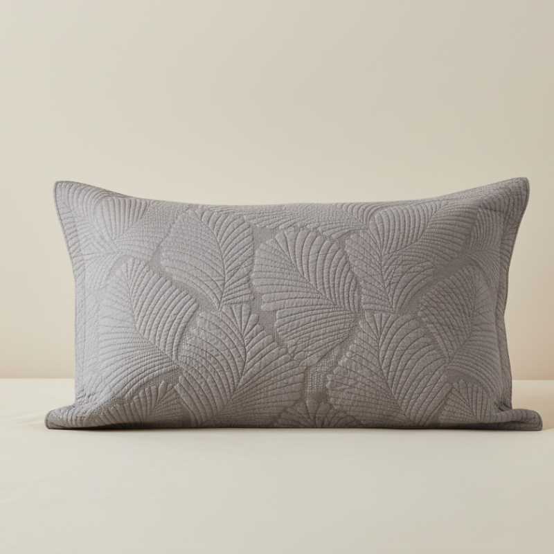 Taie d’oreiller en coton matelassé gris taupe présentée seule sur fond clair