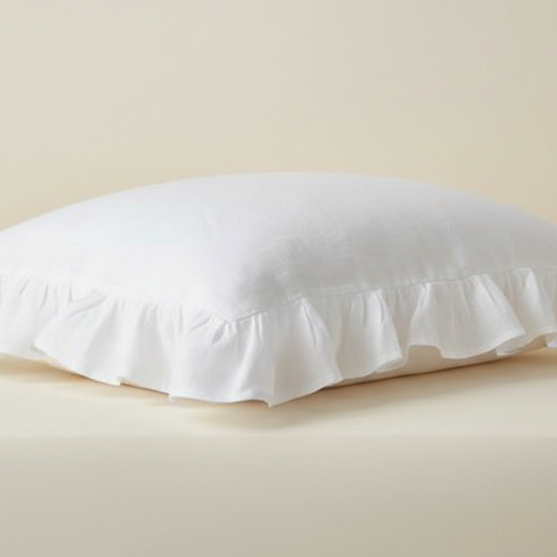 Taie d’oreiller en lin blanc à volants présentée seule sur fond clair