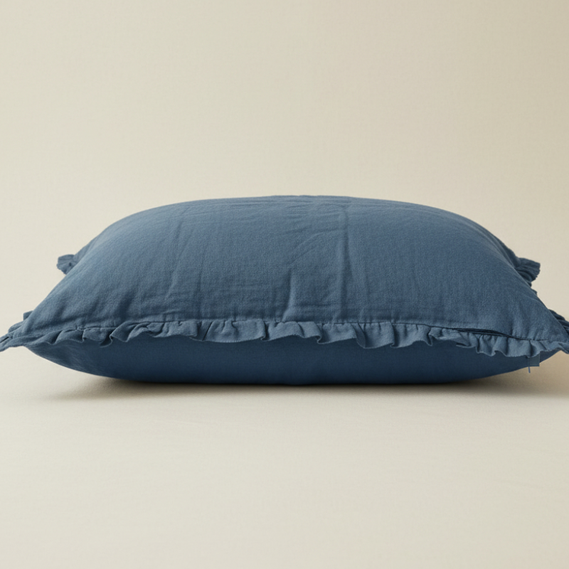 Taie d’oreiller en lin bleu à volants présentée seule sur fond clair
