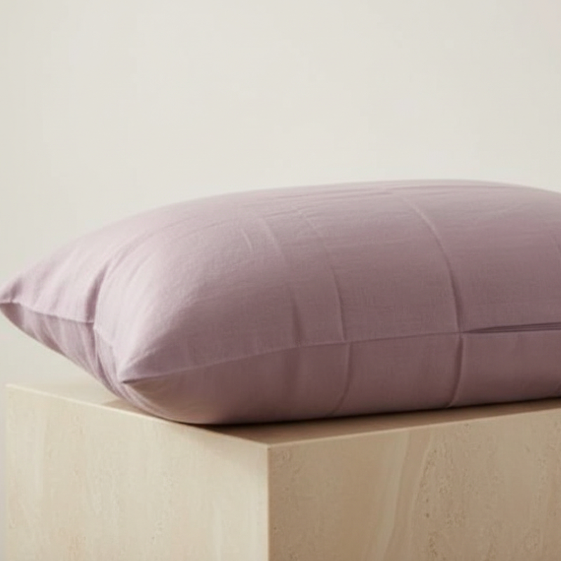 Taie d’oreiller en lin violet présentée seule sur support bois clair