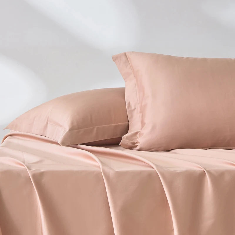 Taie d’oreiller en satin de coton rose pêche présentée seule sur fond clair