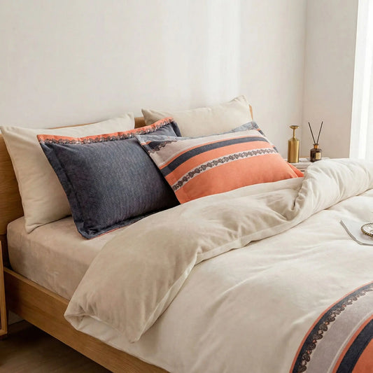 Taies d’oreiller en flanelle orange et gris posées sur un lit en bois clair avec linge de lit blanc cassé