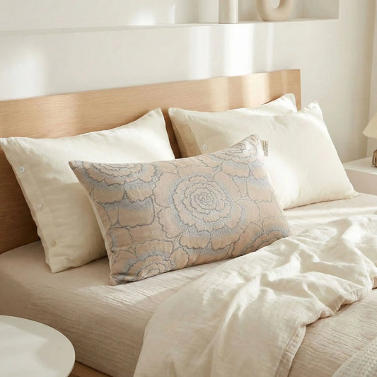 Taies d’oreiller en gaze de coton à motifs floraux posées sur un lit en bois clair