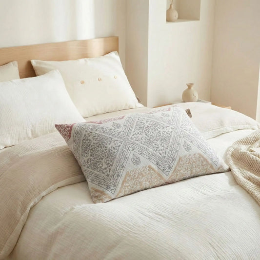 Taies d’oreiller en gaze de coton à motifs géométriques posées sur un lit en bois clair