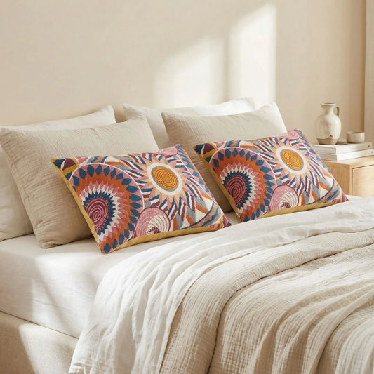 Taies d’oreiller en gaze de coton colorée posées sur un lit en bois clair