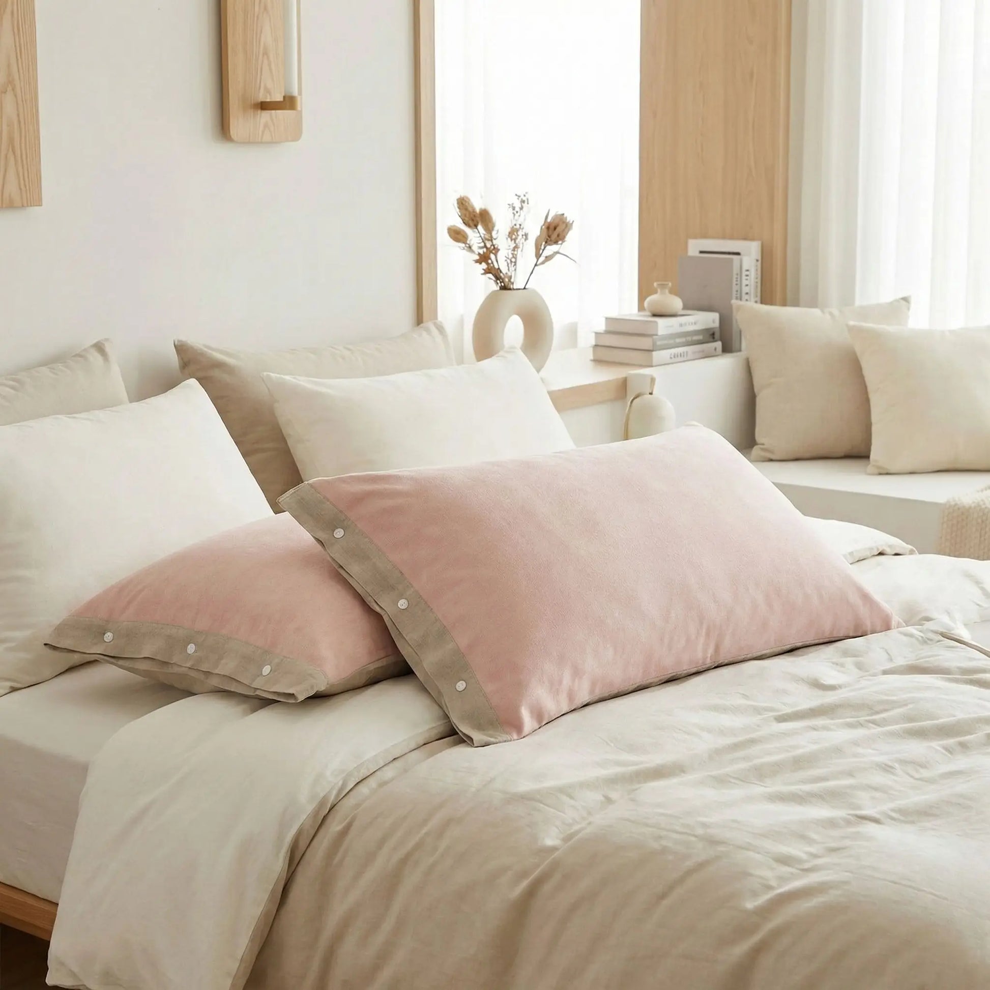 Taies d’oreiller en gaze de coton rose café posées sur un lit en bois clair