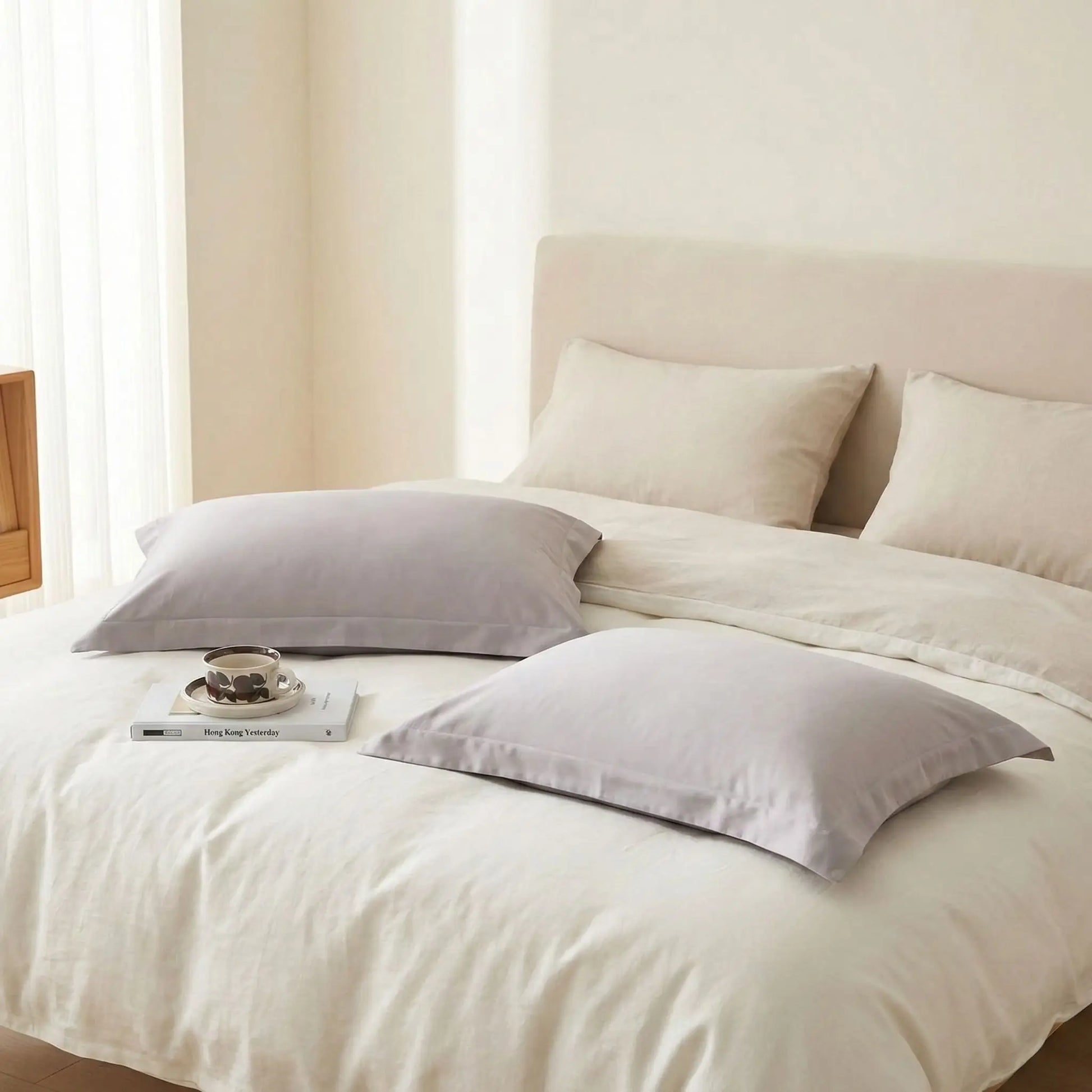 Taies d’oreiller en satin de coton grises posées sur un lit moderne