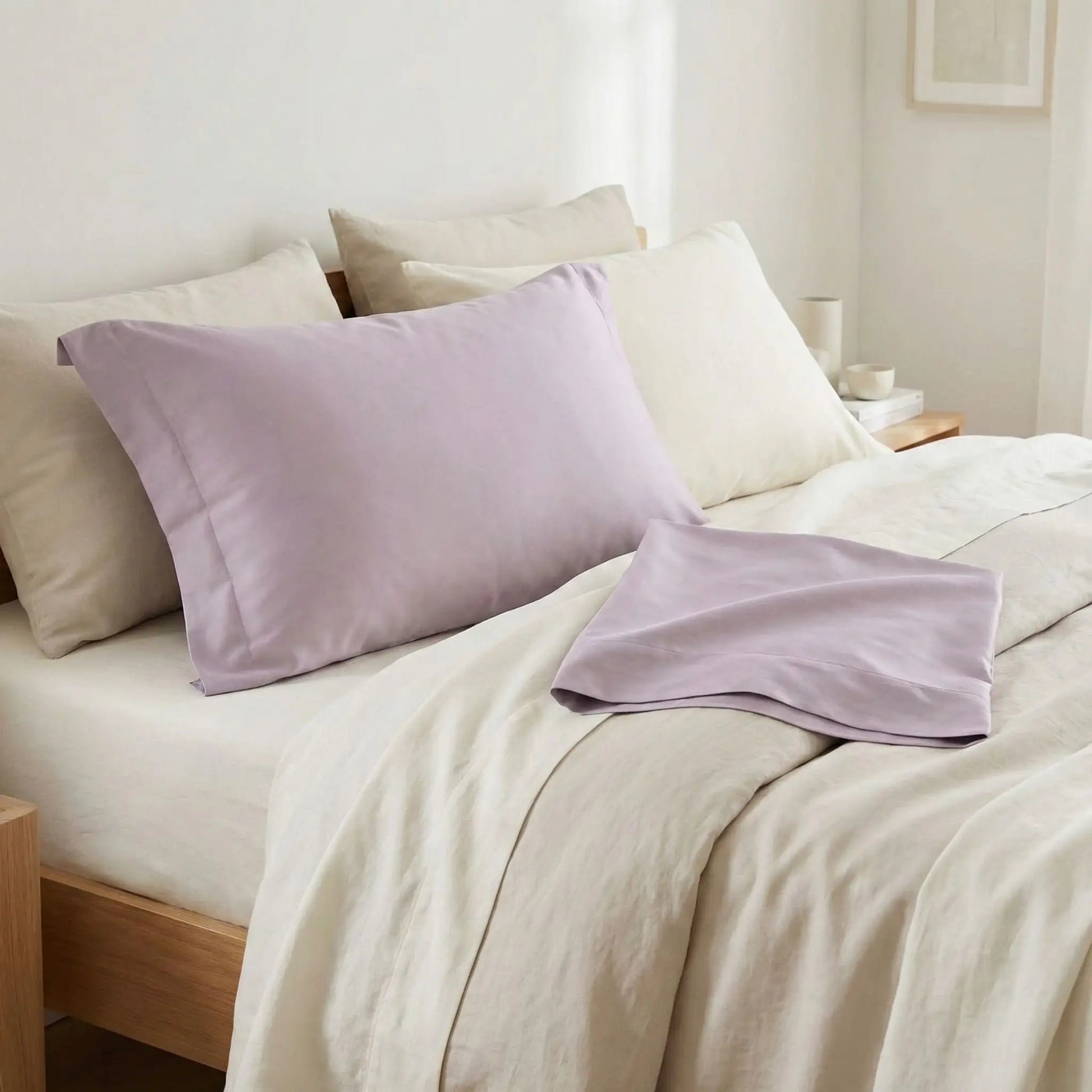 Taies d’oreiller en satin de coton violet grisée posées sur un lit moderne